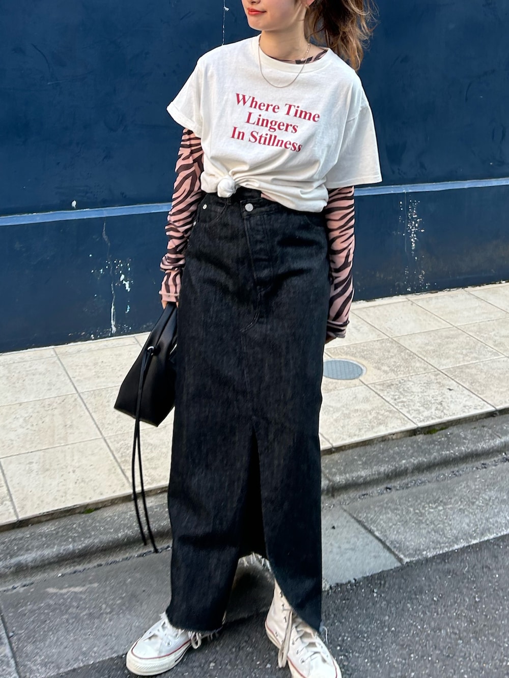 ブラック系のTシャツ/カットソー、ホワイト系のTシャツ/カットソー、ブラック系のスカートを着用したレディースの春コーディネートの10枚目の写真