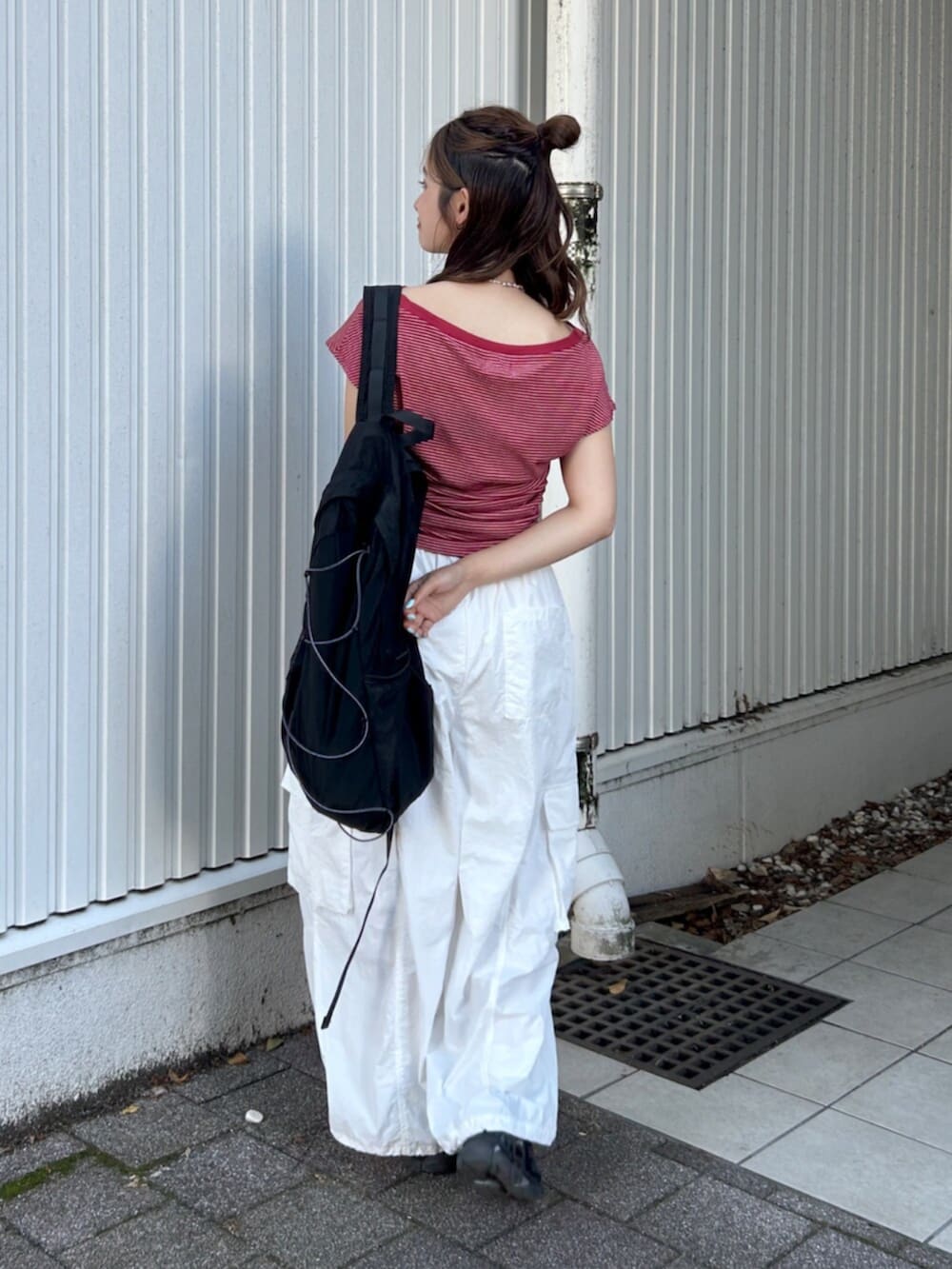 ブラック系のバックパック/リュック、ホワイト系のその他パンツ、レッド系のTシャツ/カットソーを着用したレディースの夏コーディネートの4枚目の写真