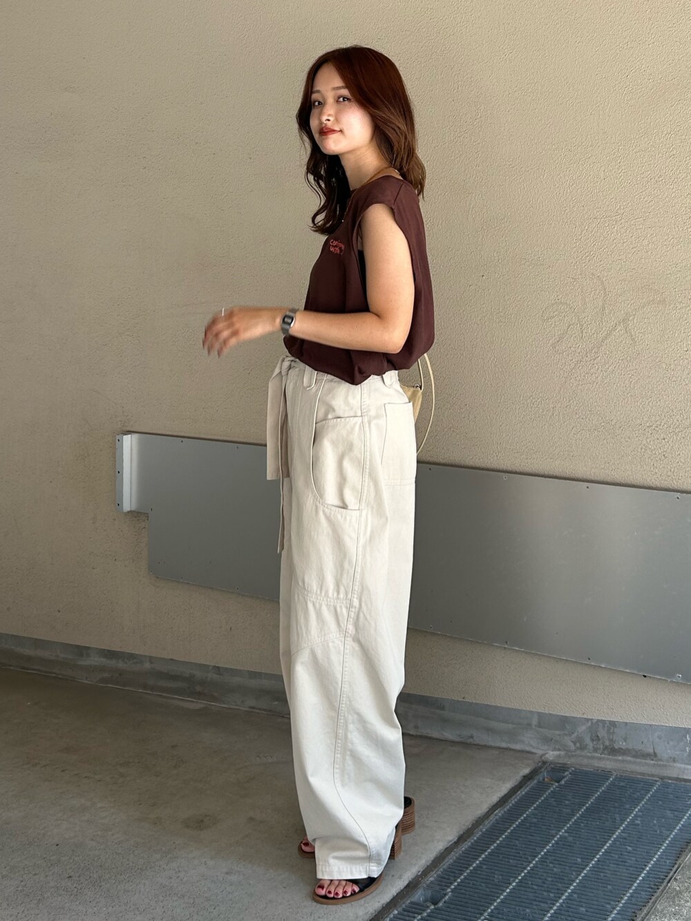 ホワイト系のその他パンツ、ブラック系のサンダル、ブラウン系のタンクトップを着用したレディースの夏コーディネートの2枚目の写真