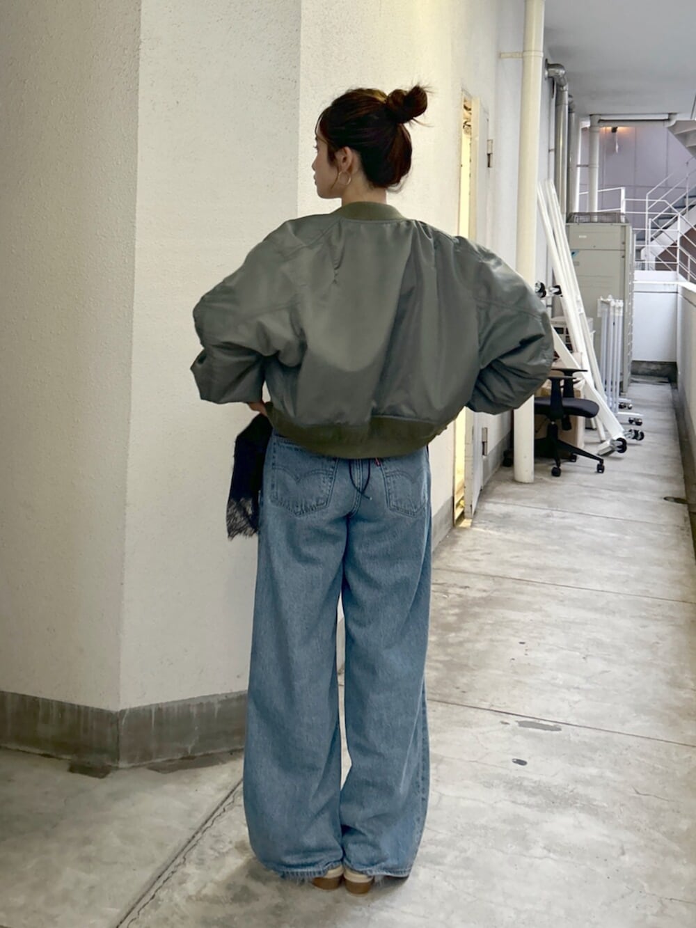 ブルー系のデニムパンツ、グリーン系のMA-1、グレー系のキャミソールを着用したレディースの夏コーディネートの3枚目の写真