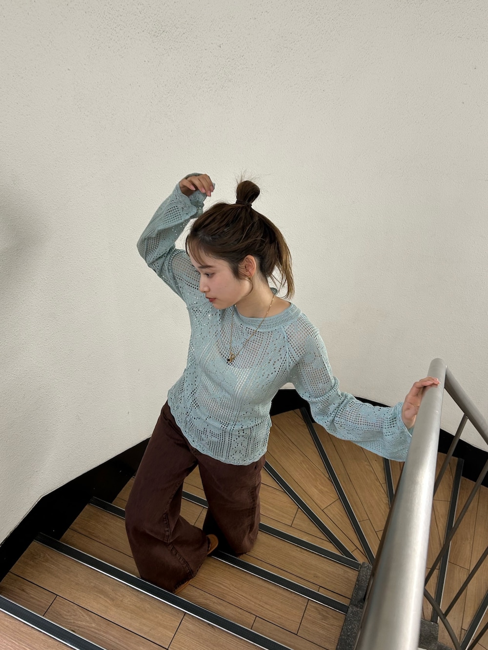 ブラウン系のデニムパンツ、ブルー系のニット/セーターを着用したレディースの春コーディネートの7枚目の写真