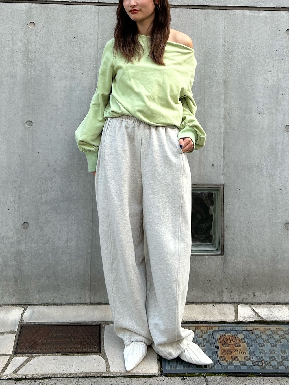 ホワイト系のパンプス、ホワイト系のスウェットパンツ、グリーン系のTシャツ/カットソーを着用したレディースの冬コーディネートの2枚目の写真