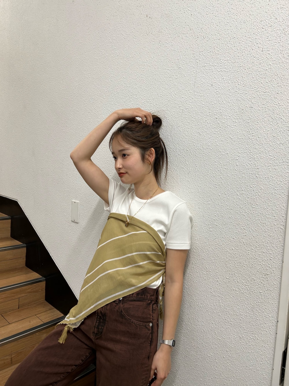 ブラウン系のデニムパンツ、ホワイト系のTシャツ/カットソー、イエロー系のバンダナ/スカーフを着用したレディースの春コーディネートの6枚目の写真