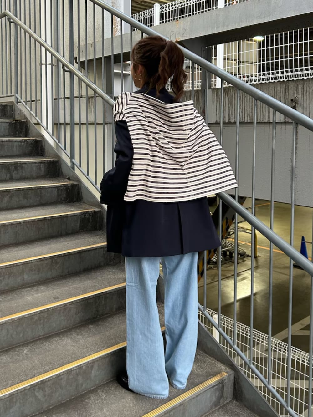 イエロー系のニット/セーター、ブルー系のテーラードジャケット、ブルー系のデニムパンツを着用したレディースの冬コーディネートの3枚目の写真