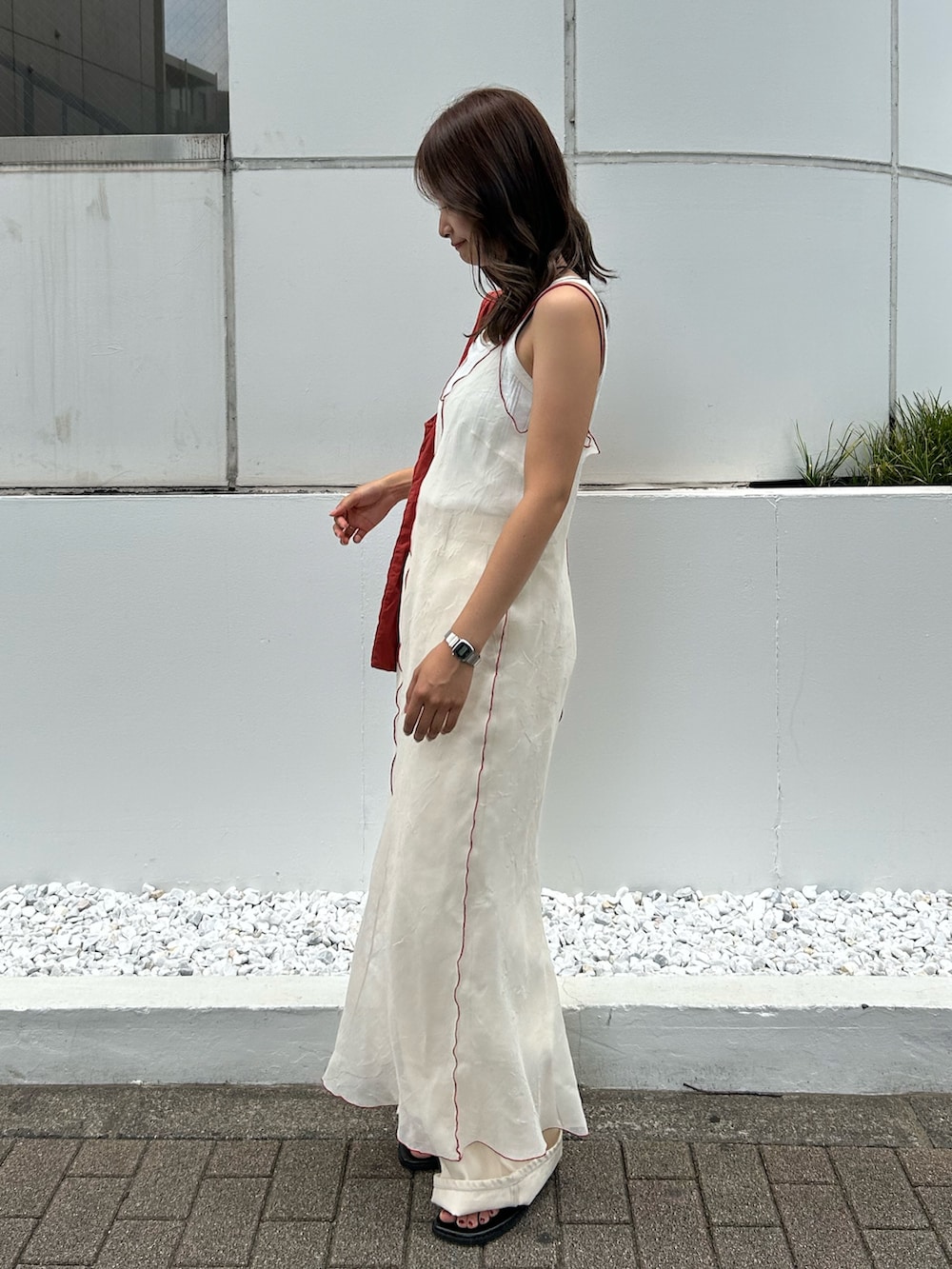 ホワイト系のタンクトップ、ホワイト系のワンピース、オレンジ系のトートバッグを着用したレディースの夏コーディネートの2枚目の写真