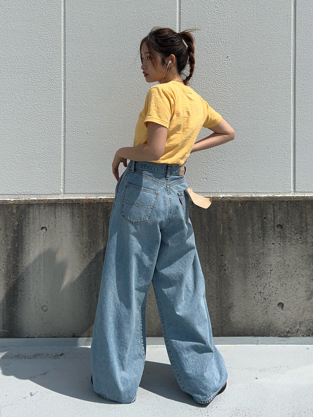 イエロー系のTシャツ/カットソー、ブルー系のデニムパンツを着用したレディースの春コーディネートの4枚目の写真