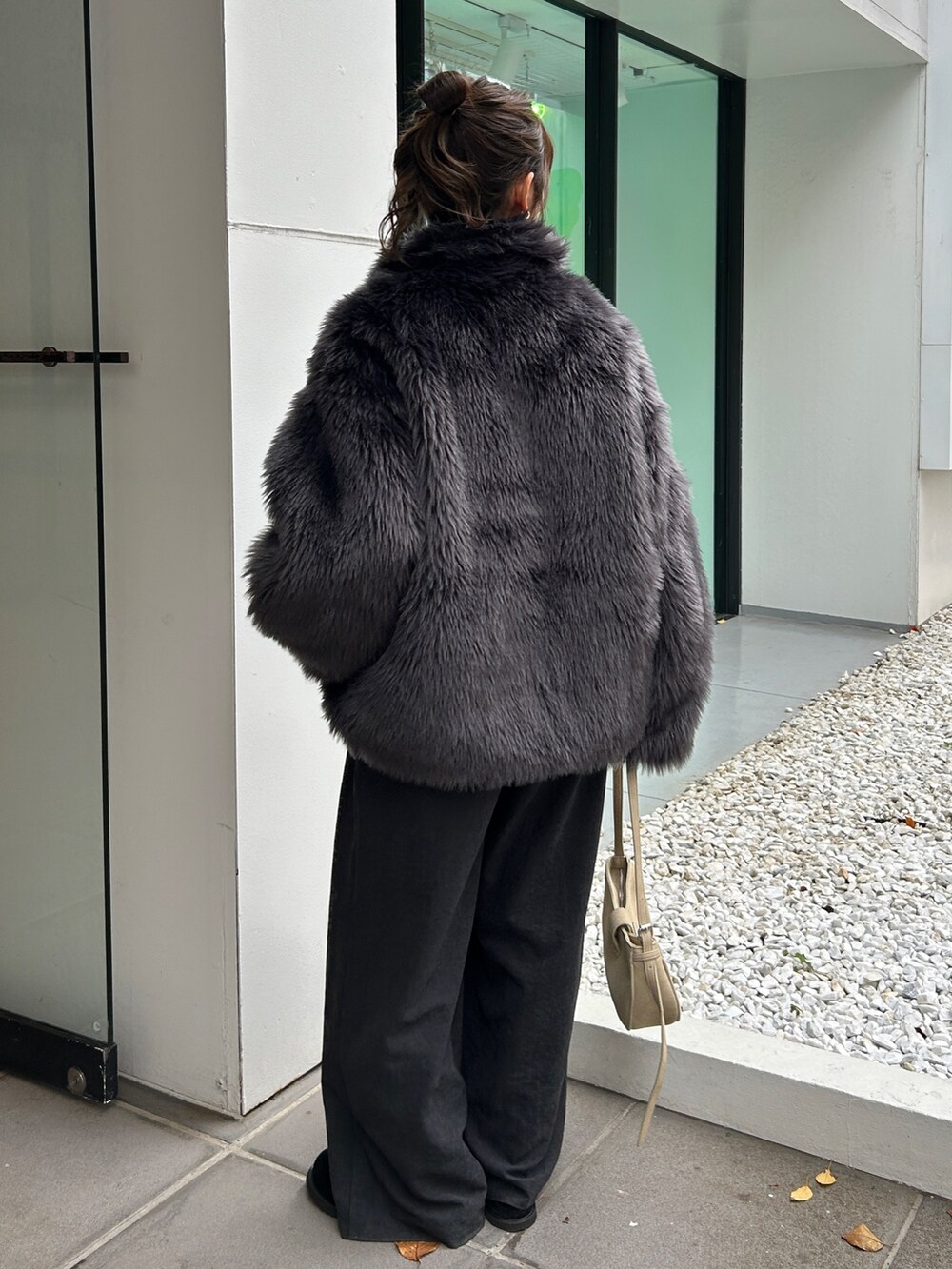 グレー系のダウンジャケット/コート、グレー系のその他パンツ、ブラック系のスリッポンを着用したレディースの秋コーディネートの5枚目の写真