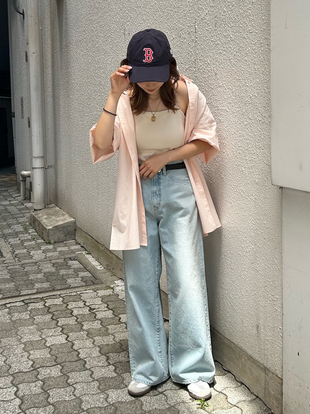 ブルー系のデニムパンツ、ピンク系のシャツ/ブラウス、ホワイト系のキャミソールを着用したレディースの春コーディネートの2枚目の写真