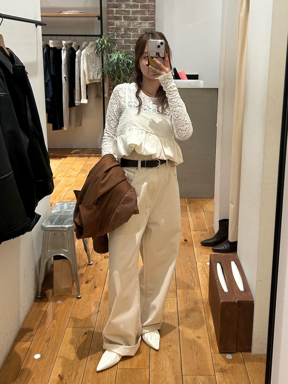 ブラウン系のテーラードジャケット、ホワイト系のパンプス、ホワイト系のデニムパンツを着用したレディースの冬コーディネートの7枚目の写真