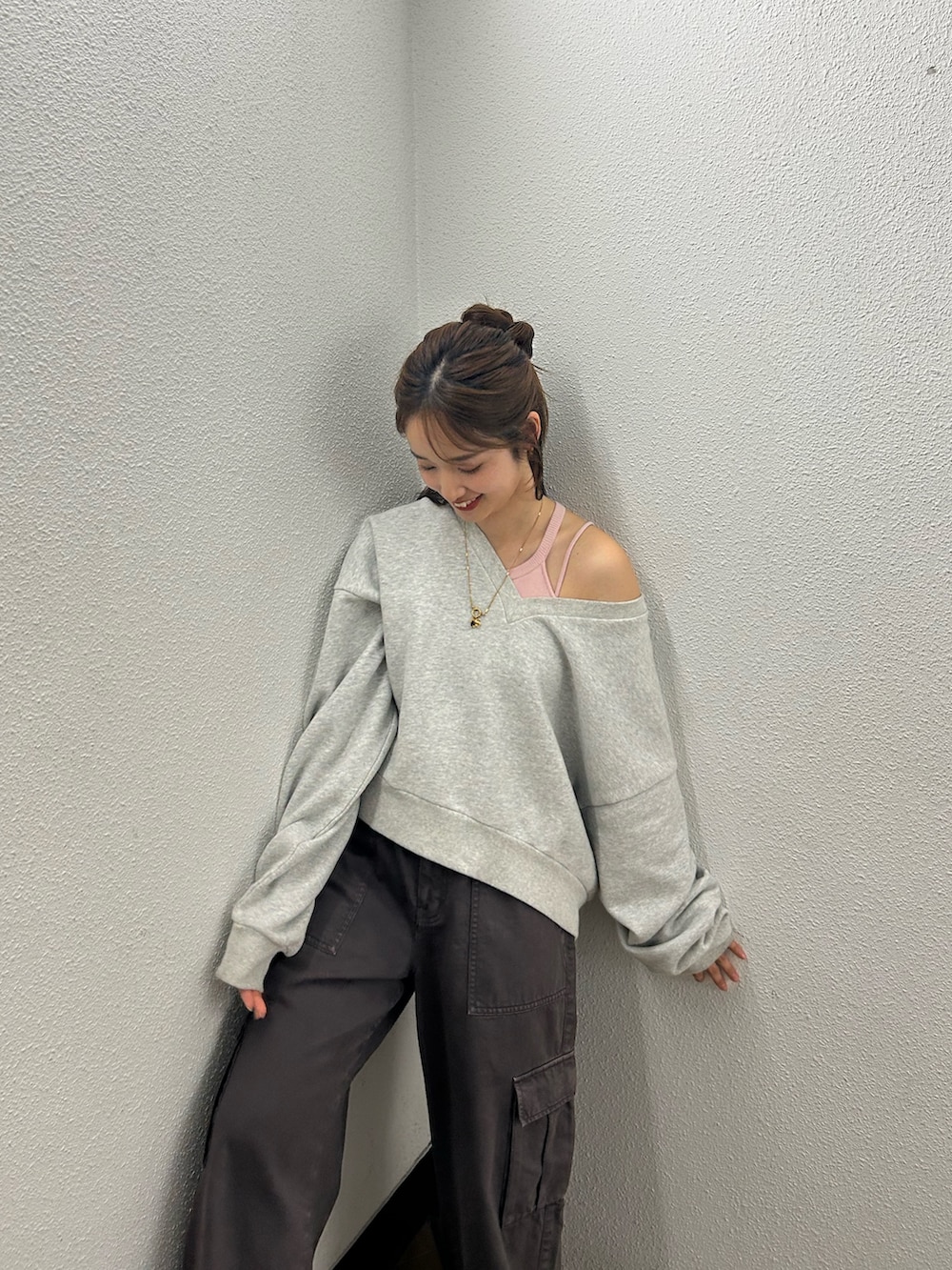 グレー系のスウェット、ブラウン系のカーゴパンツ、ピンク系のキャミソールを着用したレディースの春コーディネートの5枚目の写真