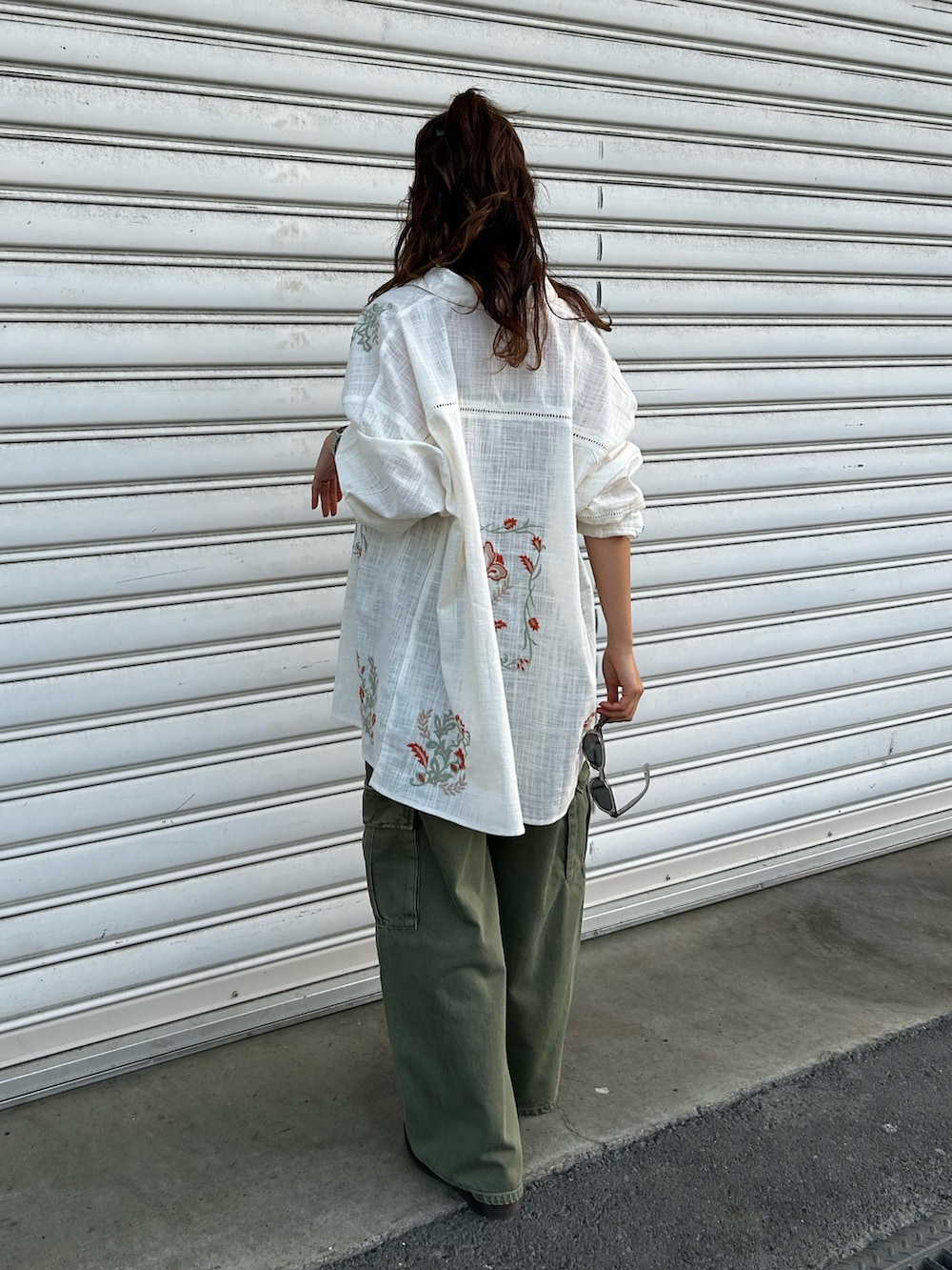 グリーン系のカーゴパンツ、ホワイト系のシャツ/ブラウス、ブラウン系のキャミソールを着用したレディースの春コーディネートの3枚目の写真