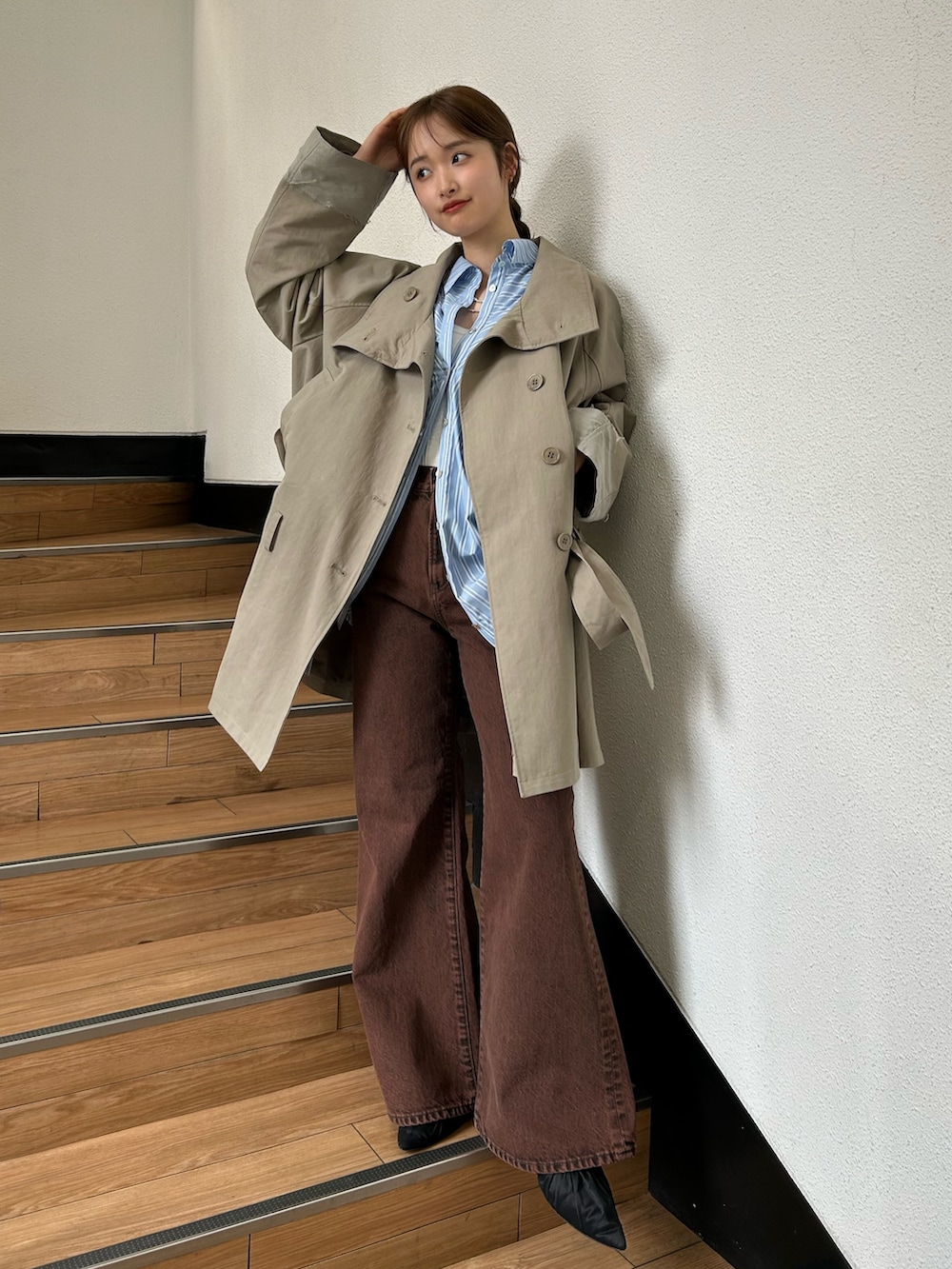 グリーン系のトレンチコート、ブラック系のパンプス、ブルー系のシャツ/ブラウスを着用したレディースの春コーディネートの3枚目の写真