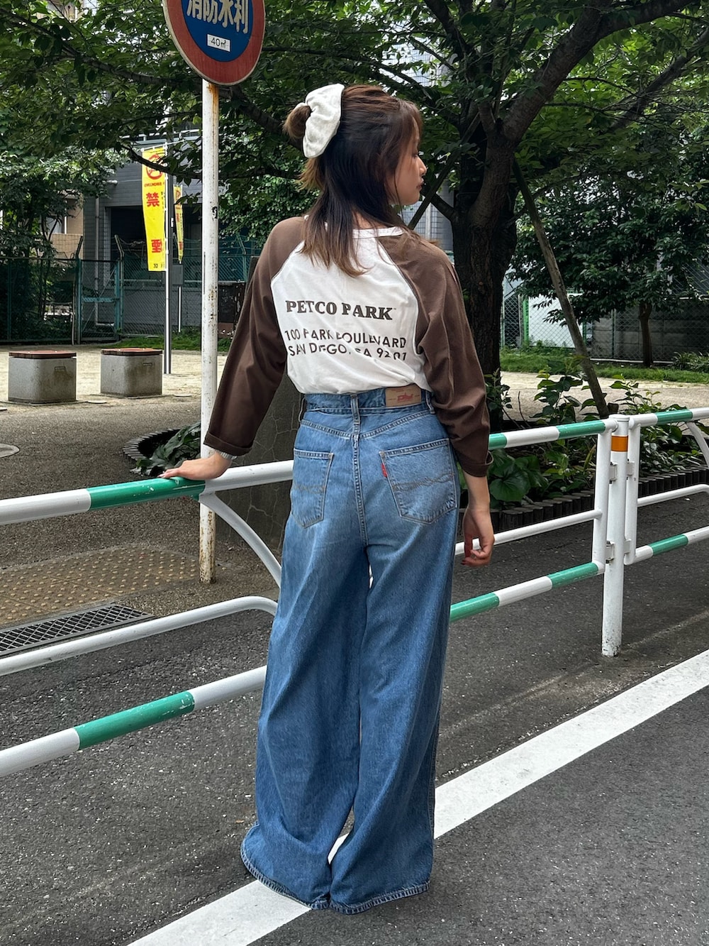 ブルー系のデニムパンツ、ベージュ系のローファー、ブラウン系のTシャツ/カットソーを着用したレディースの夏コーディネートの7枚目の写真