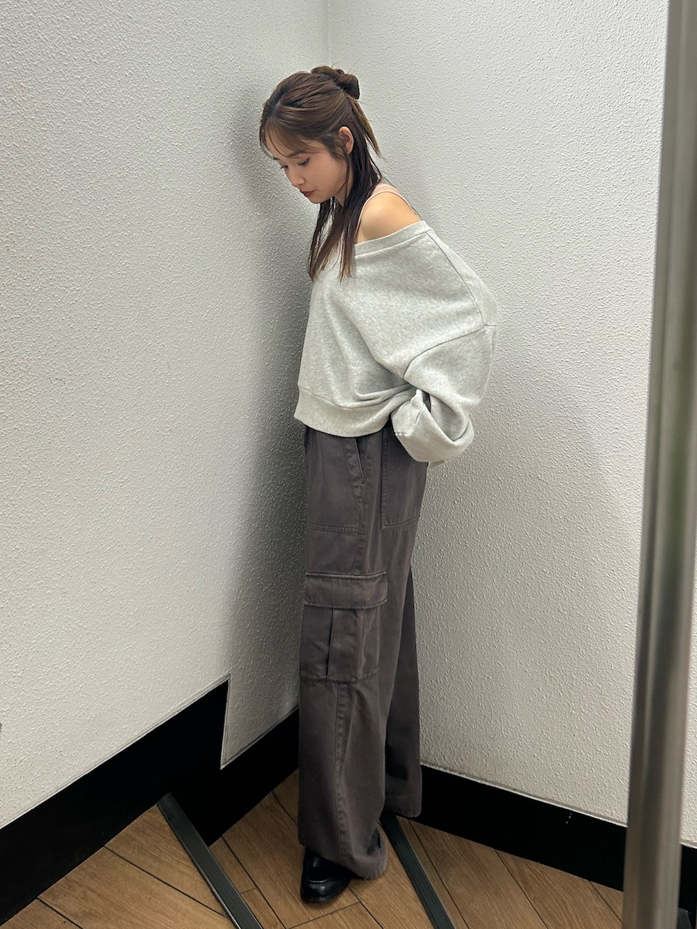 グレー系のスウェット、ブラウン系のカーゴパンツ、ピンク系のキャミソールを着用したレディースの春コーディネートの2枚目の写真