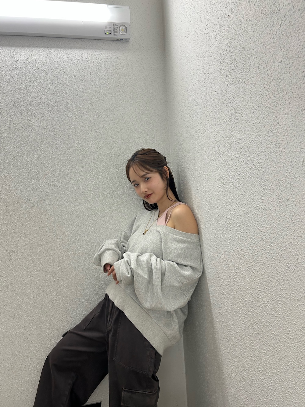 グレー系のスウェット、ブラウン系のカーゴパンツ、ピンク系のキャミソールを着用したレディースの春コーディネートの6枚目の写真