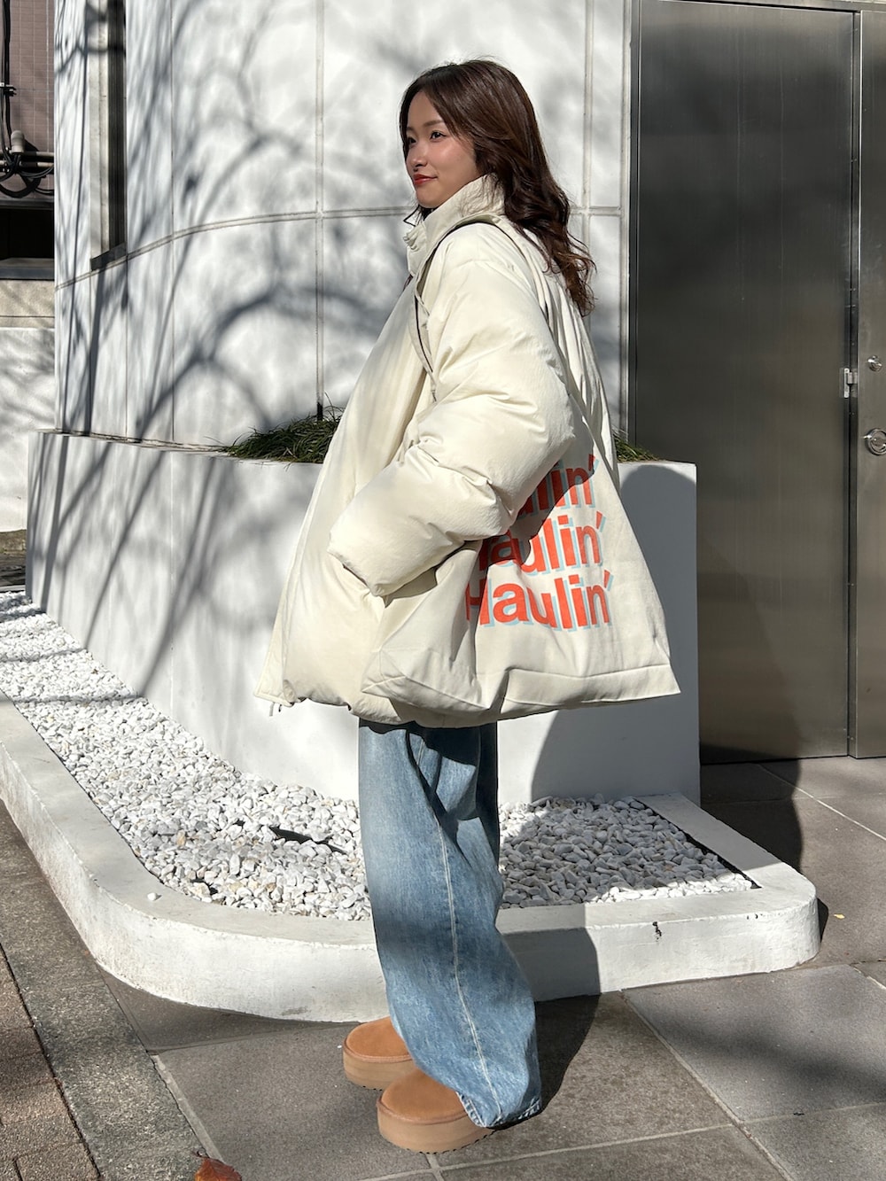 グレー系のニット/セーター、ブルー系のデニムパンツ、レッド系のニット/セーターを着用したレディースの冬コーディネートの3枚目の写真