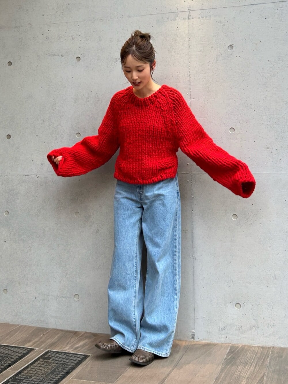 ブルー系のデニムパンツ、レッド系のニット/セーターを着用したレディースの秋コーディネートの5枚目の写真