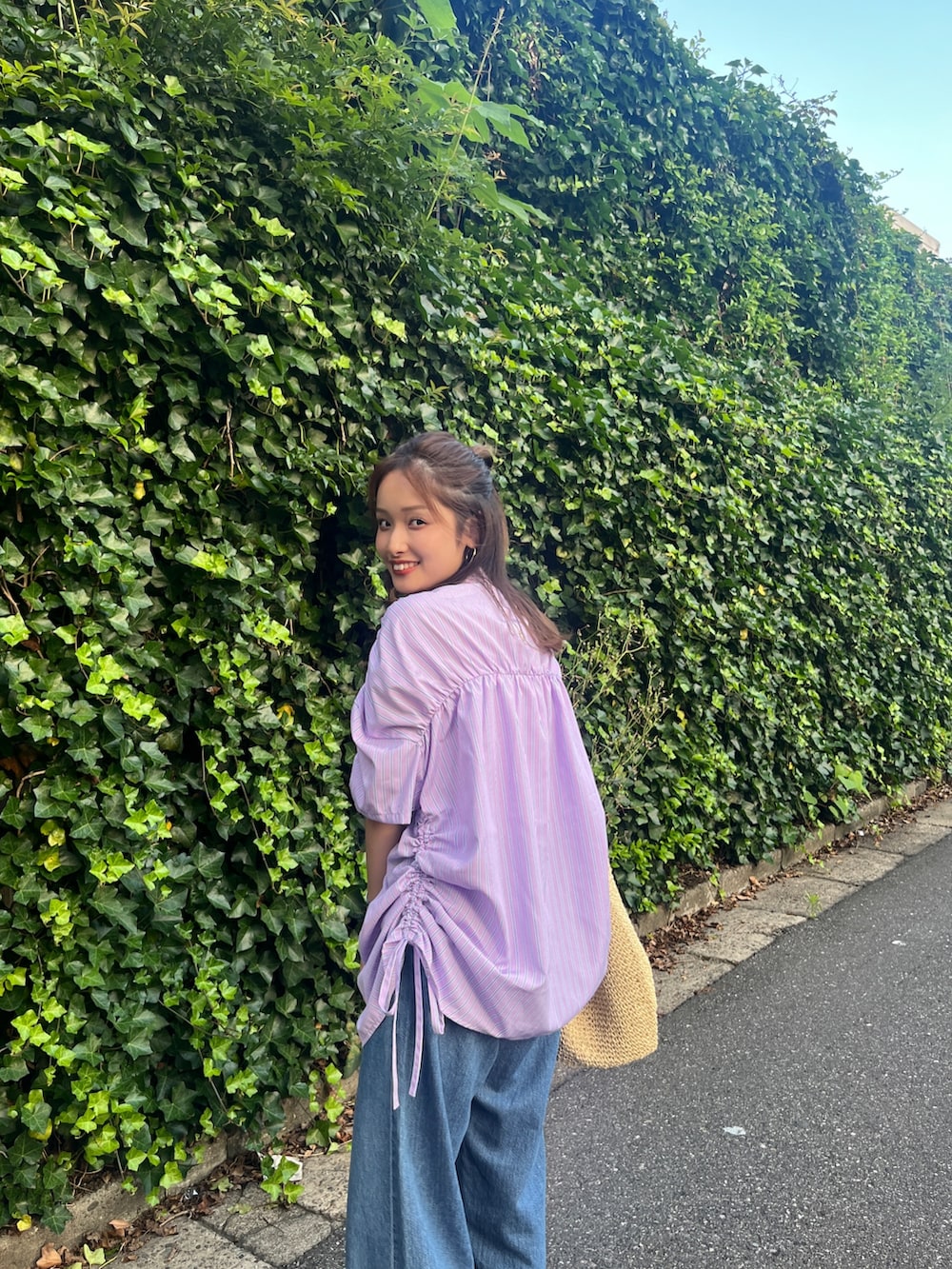 ブルー系のデニムパンツ、ブラック系のサンダル、パープル系のシャツ/ブラウスを着用したレディースの夏コーディネートの5枚目の写真