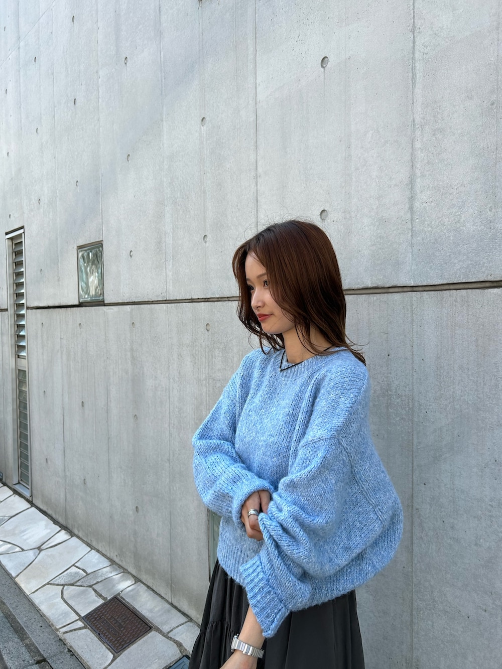 グレー系のスカート、ブラック系のネックレスを着用したレディースの秋コーディネートの5枚目の写真