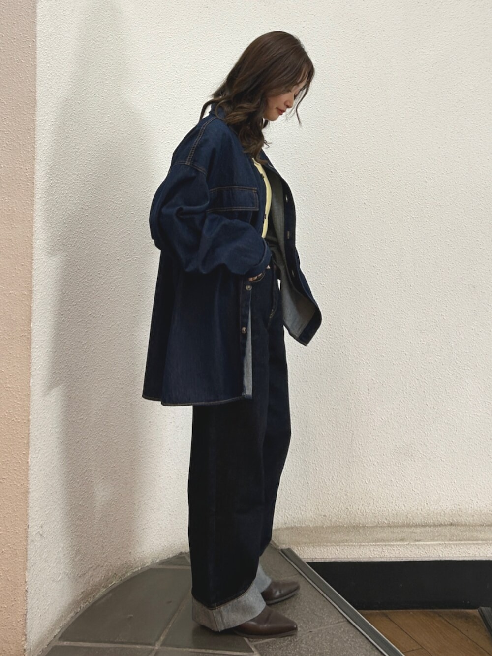 ブルー系のデニムパンツ、ブラウン系のブーツ、ブルー系のシャツ/ブラウスを着用したレディースの秋コーディネートの2枚目の写真