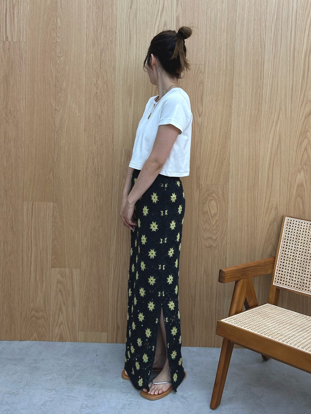 グレー系のスカート、ホワイト系のTシャツ/カットソー、シルバー系のサンダルを着用したレディースの春コーディネートの3枚目の写真