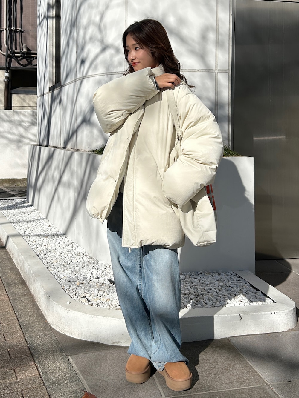 グレー系のニット/セーター、ブルー系のデニムパンツ、レッド系のニット/セーターを着用したレディースの冬コーディネートの2枚目の写真