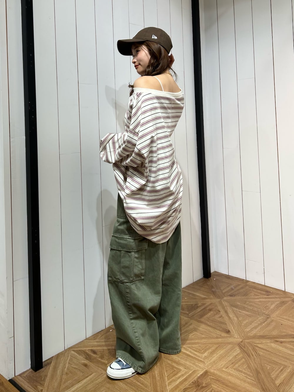 グリーン系のカーゴパンツ、ブルー系のスニーカー、ブラウン系のキャップを着用したレディースの春コーディネートの2枚目の写真