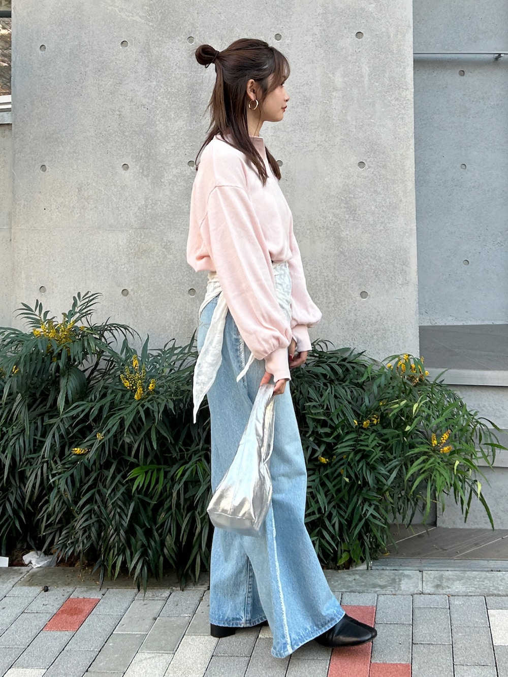 ブルー系のデニムパンツ、ブラック系のサンダル、シルバー系のハンドバッグを着用したレディースの冬コーディネートの5枚目の写真