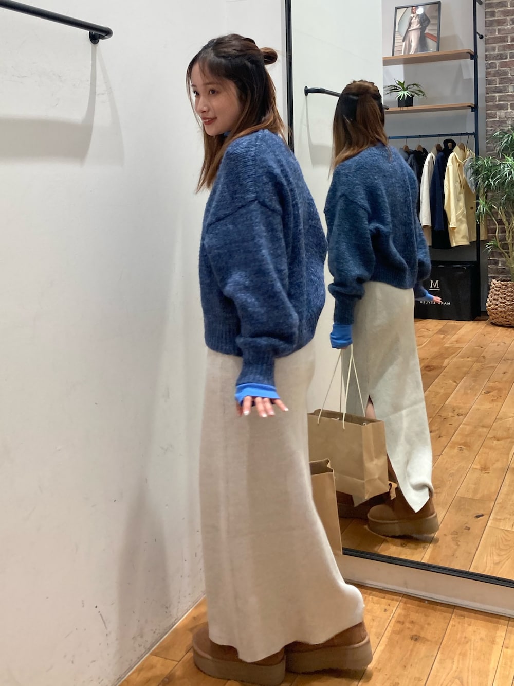 グレー系のスカート、ブルー系のTシャツ/カットソー、ブルー系のニット/セーターを着用したレディースの冬コーディネートの2枚目の写真