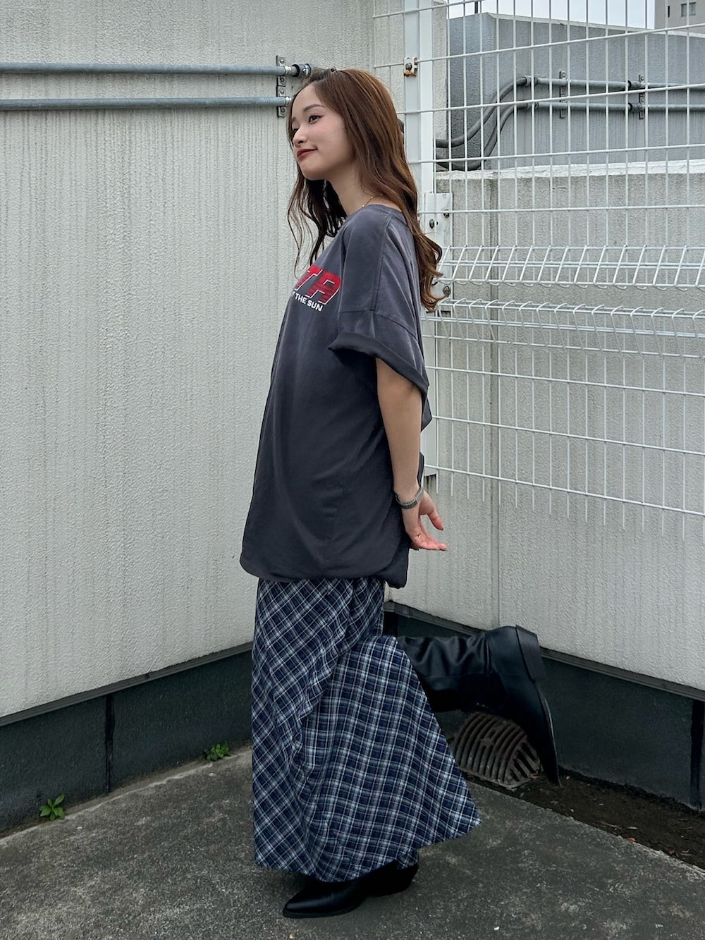 グレー系のTシャツ/カットソー、ブルー系のスカート、ブラック系のブーツを着用したレディースの春コーディネートの5枚目の写真