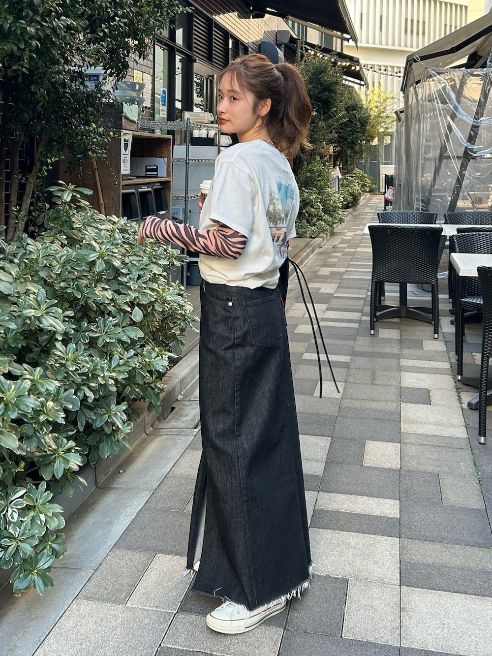 ブラック系のTシャツ/カットソー、ホワイト系のTシャツ/カットソー、ブラック系のスカートを着用したレディースの春コーディネートの2枚目の写真