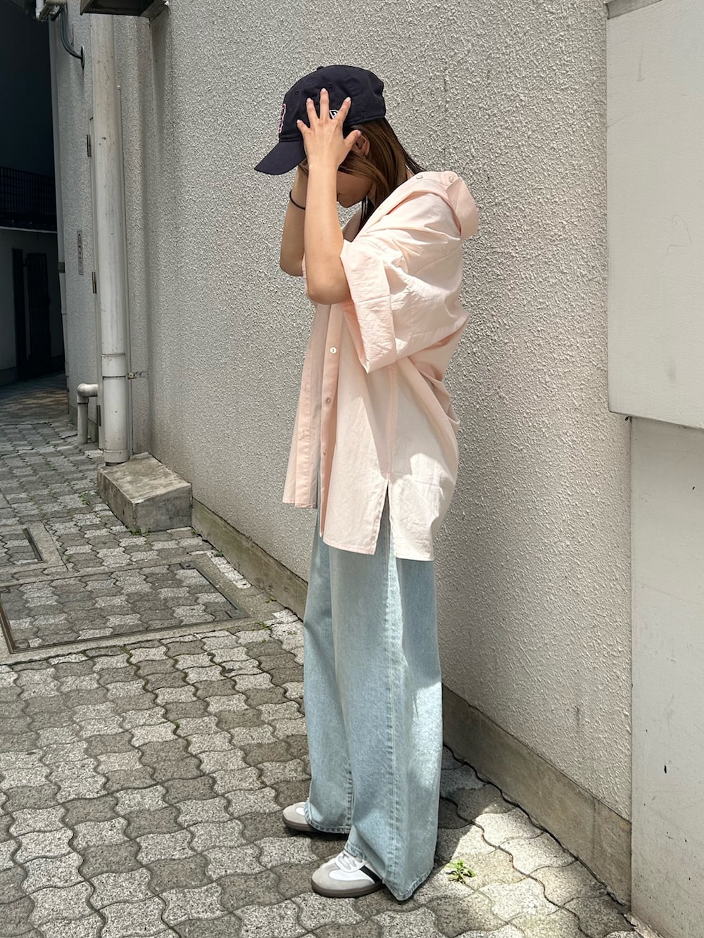 ブルー系のデニムパンツ、ピンク系のシャツ/ブラウス、ホワイト系のキャミソールを着用したレディースの春コーディネートの7枚目の写真