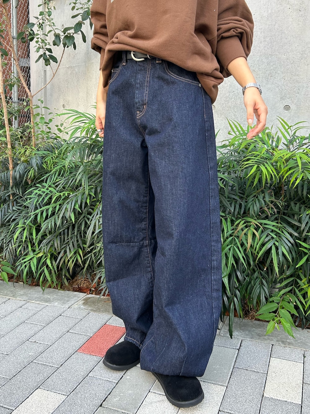 ブルー系のデニムパンツ、ブラック系のスリッポン、ブラウン系のスウェットを着用したレディースの冬コーディネートの7枚目の写真