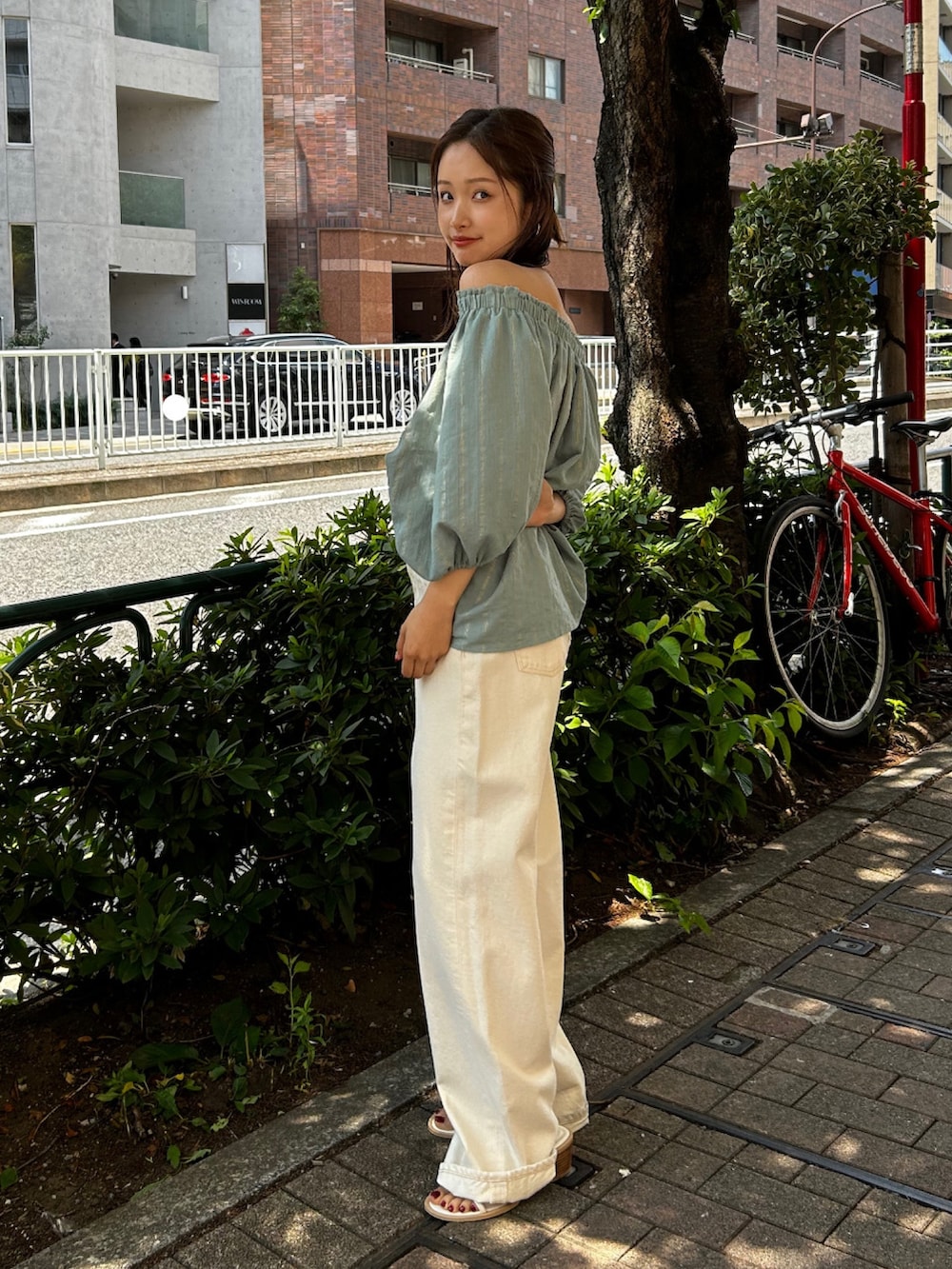 ホワイト系のデニムパンツ、グリーン系のシャツ/ブラウス、ホワイト系のサンダルを着用したレディースの夏コーディネートの2枚目の写真