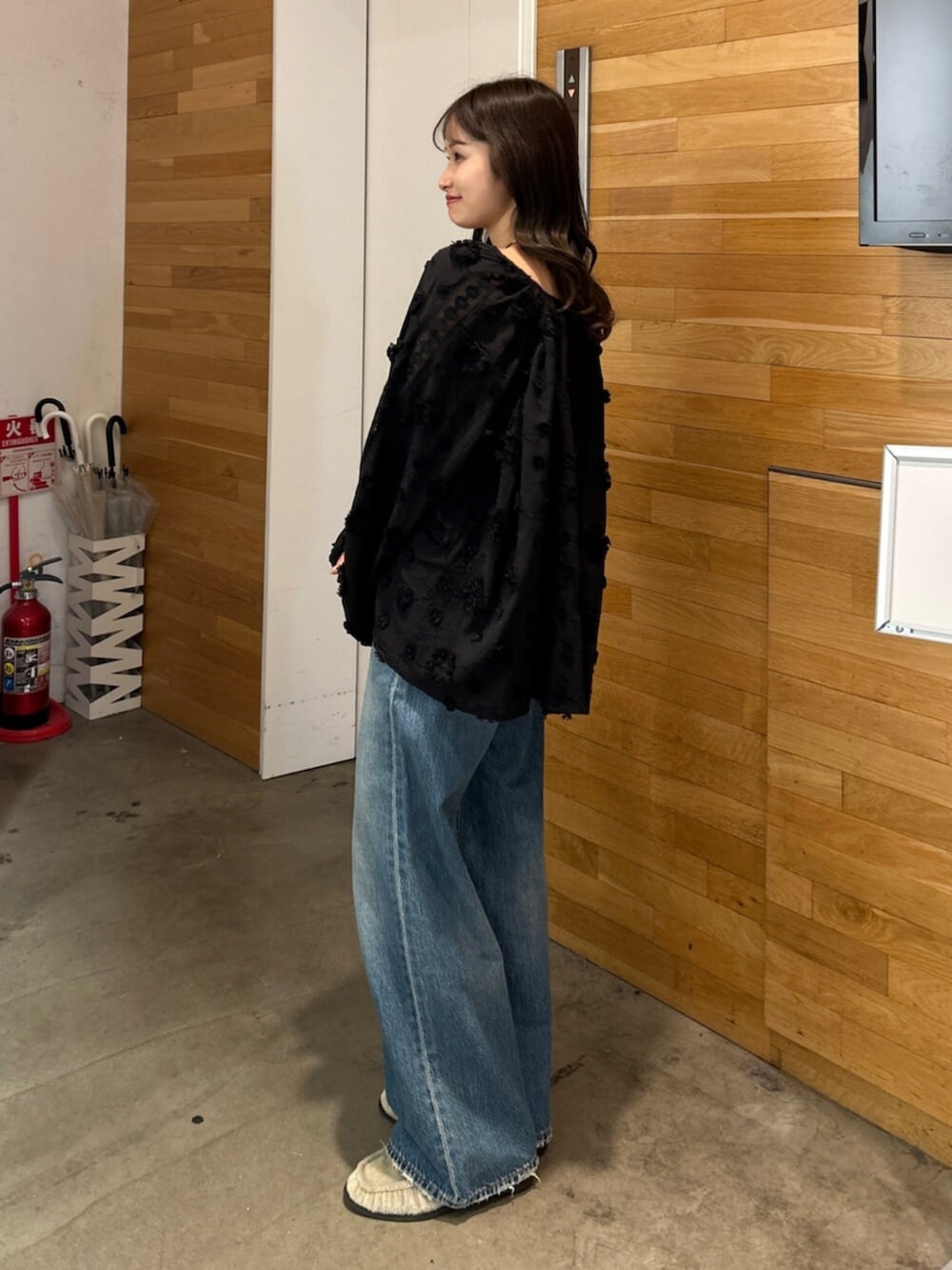 ブルー系のデニムパンツ、ブラック系のシャツ/ブラウス、ベージュ系のローファーを着用したレディースの秋コーディネートの4枚目の写真