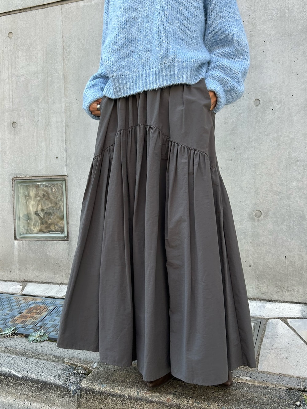 グレー系のスカート、ブラック系のネックレスを着用したレディースの秋コーディネートの7枚目の写真