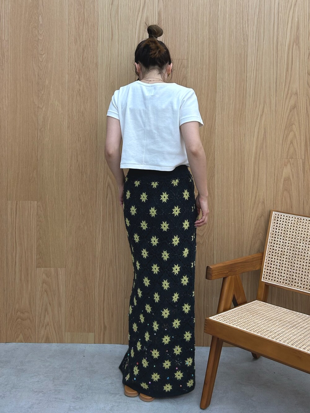 グレー系のスカート、ホワイト系のTシャツ/カットソー、シルバー系のサンダルを着用したレディースの春コーディネートの4枚目の写真