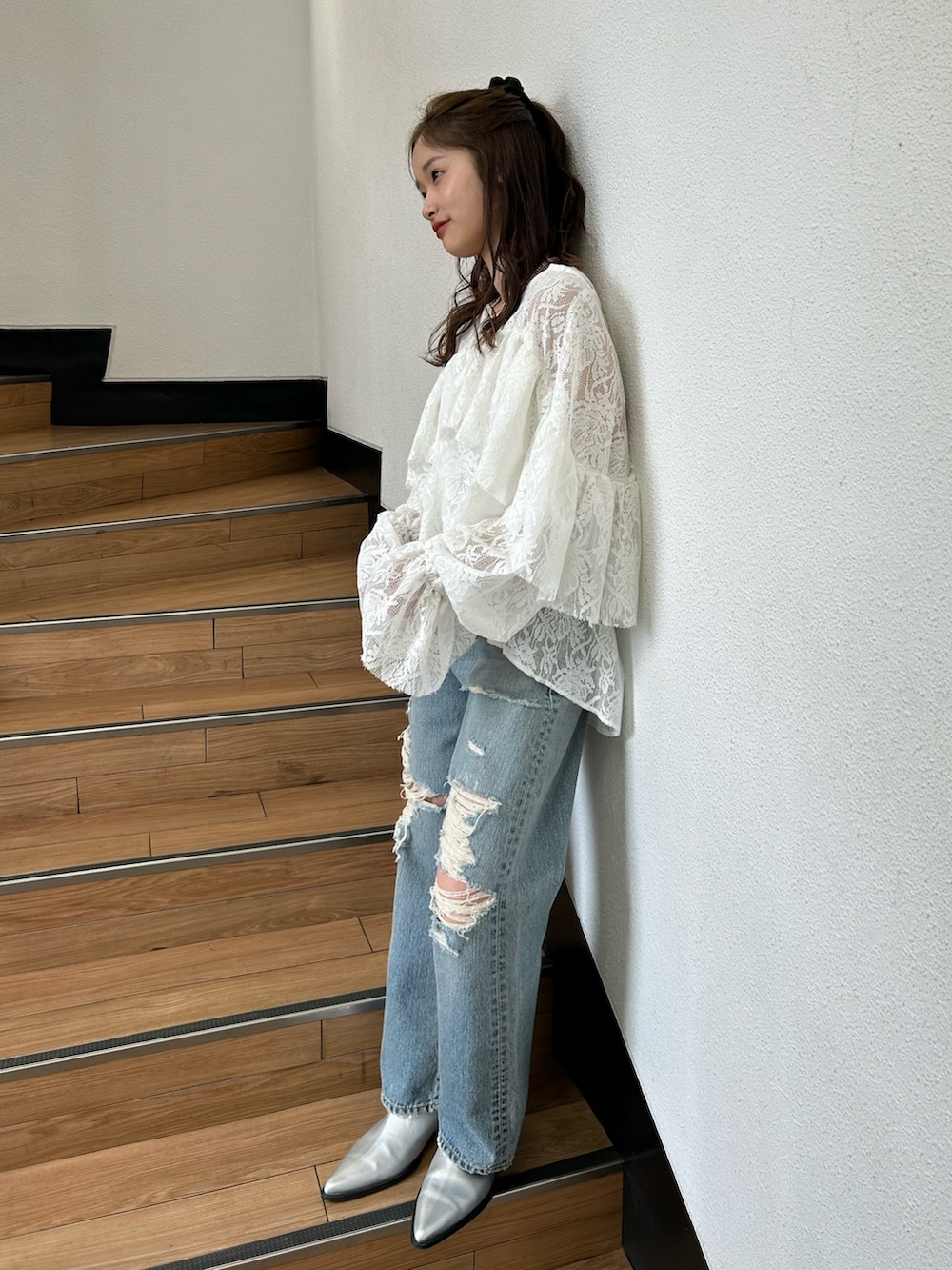ブルー系のデニムパンツ、シルバー系のブーツ、ホワイト系のシャツ/ブラウスを着用したレディースの春コーディネートの2枚目の写真