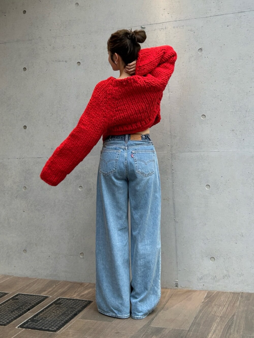 ブルー系のデニムパンツ、レッド系のニット/セーターを着用したレディースの秋コーディネートの4枚目の写真