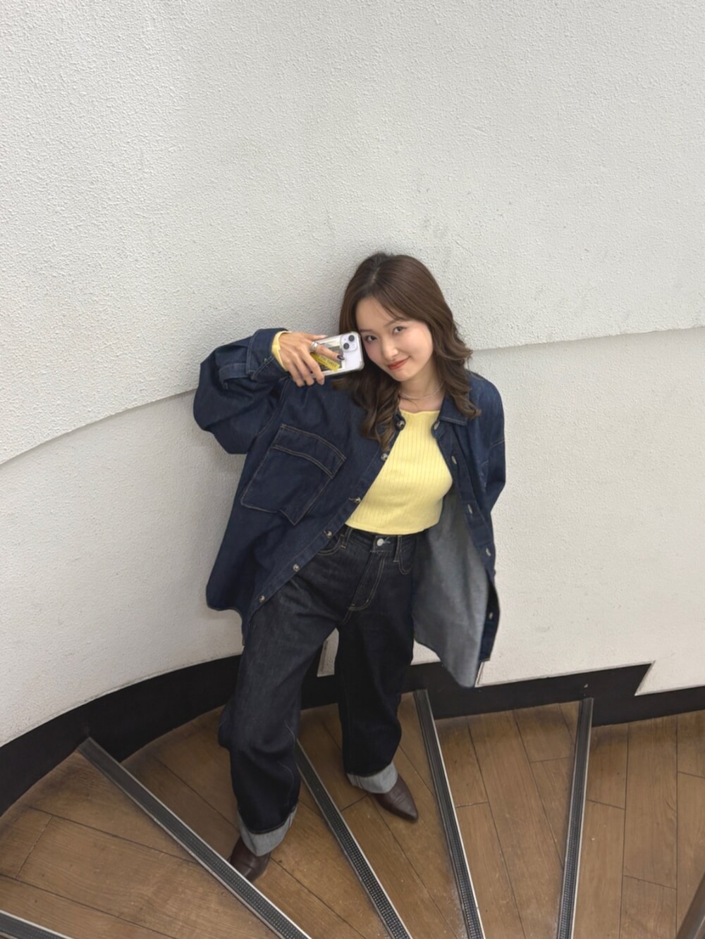 ブルー系のデニムパンツ、ブラウン系のブーツ、ブルー系のシャツ/ブラウスを着用したレディースの秋コーディネートの5枚目の写真