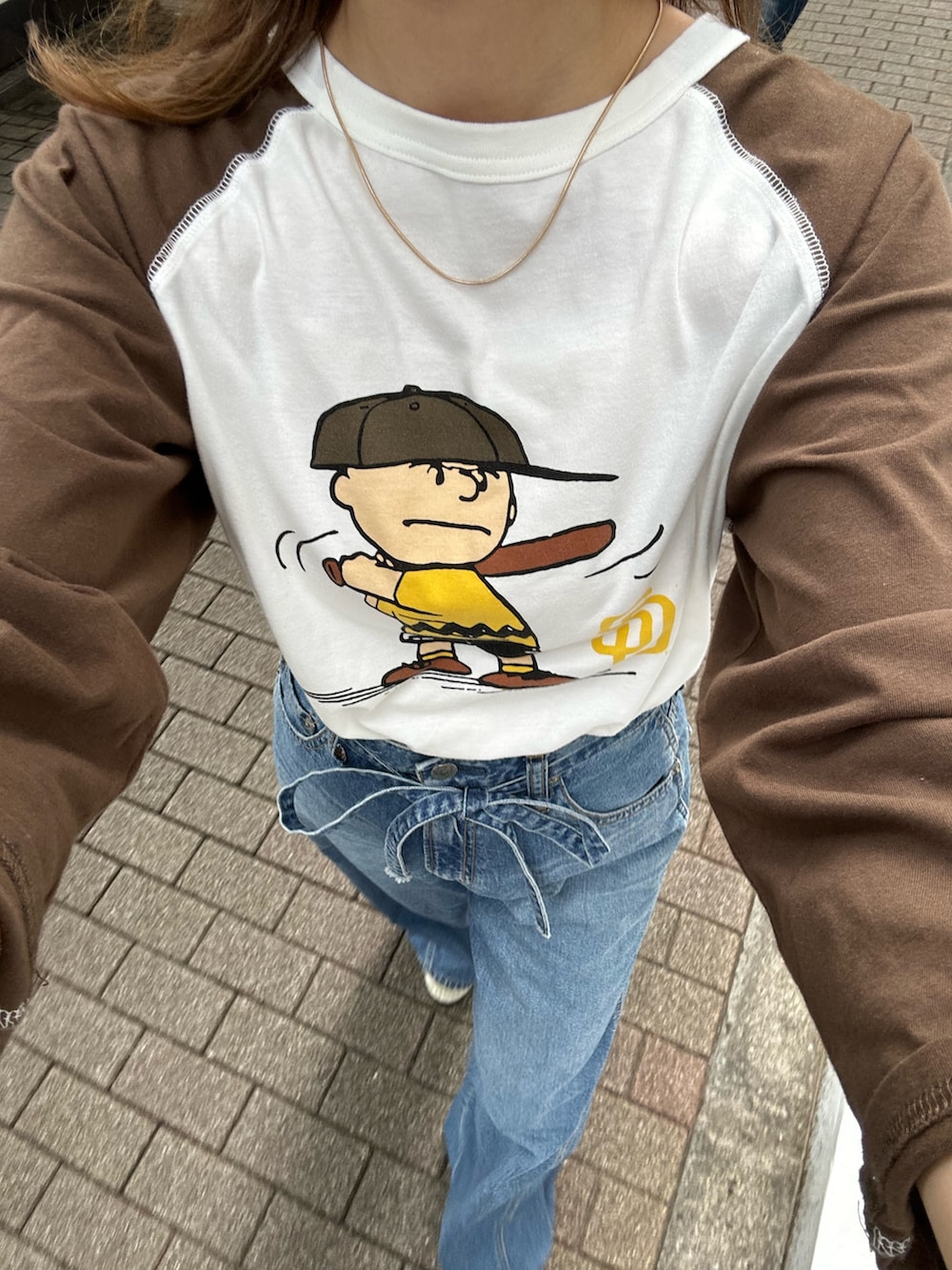 ブルー系のデニムパンツ、ベージュ系のローファー、ブラウン系のTシャツ/カットソーを着用したレディースの夏コーディネートの8枚目の写真