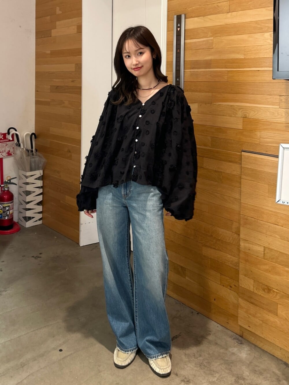 ブルー系のデニムパンツ、ブラック系のシャツ/ブラウス、ベージュ系のローファーを着用したレディースの秋コーディネートの2枚目の写真