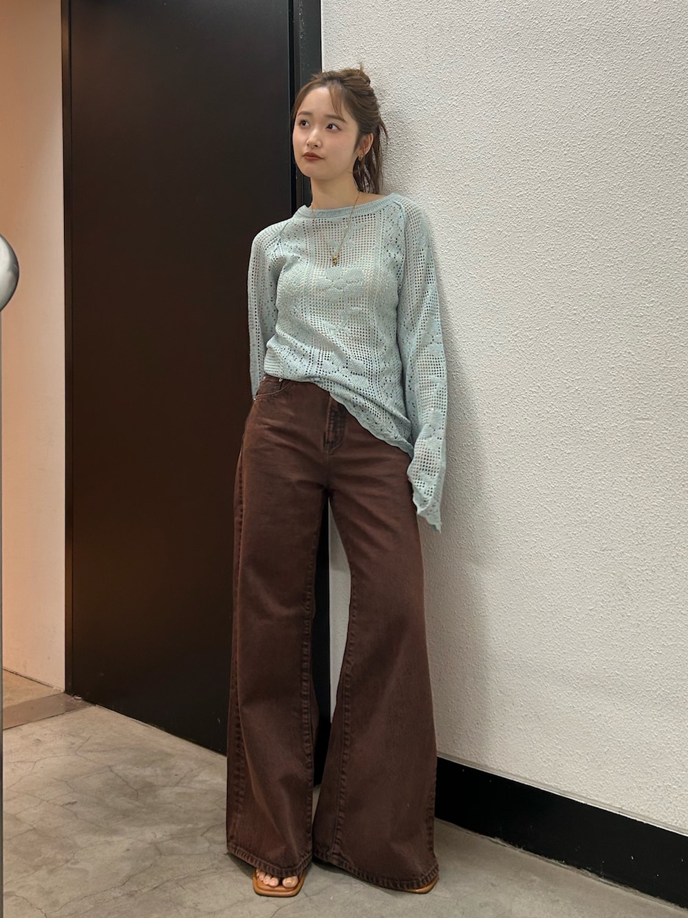 ブラウン系のデニムパンツ、ブルー系のニット/セーターを着用したレディースの春コーディネートの2枚目の写真