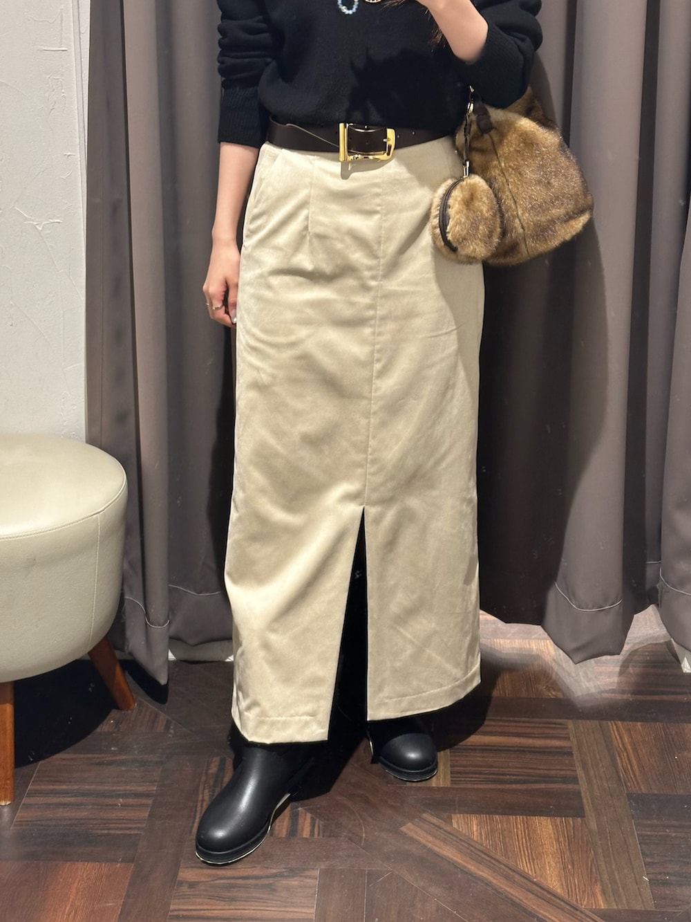 ブラック系のニット/セーター、ベージュ系のスカート、イエロー系のハンドバッグを着用したレディースの秋コーディネートの2枚目の写真