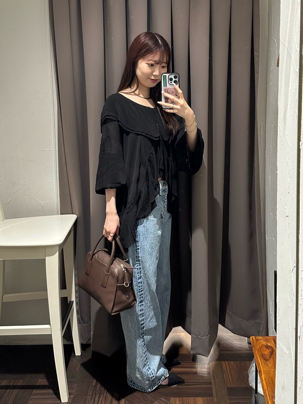 ブルー系のデニムパンツ、ブラック系のシャツ/ブラウス、ブラウン系のボストンバッグを着用したレディースの夏コーディネートの2枚目の写真