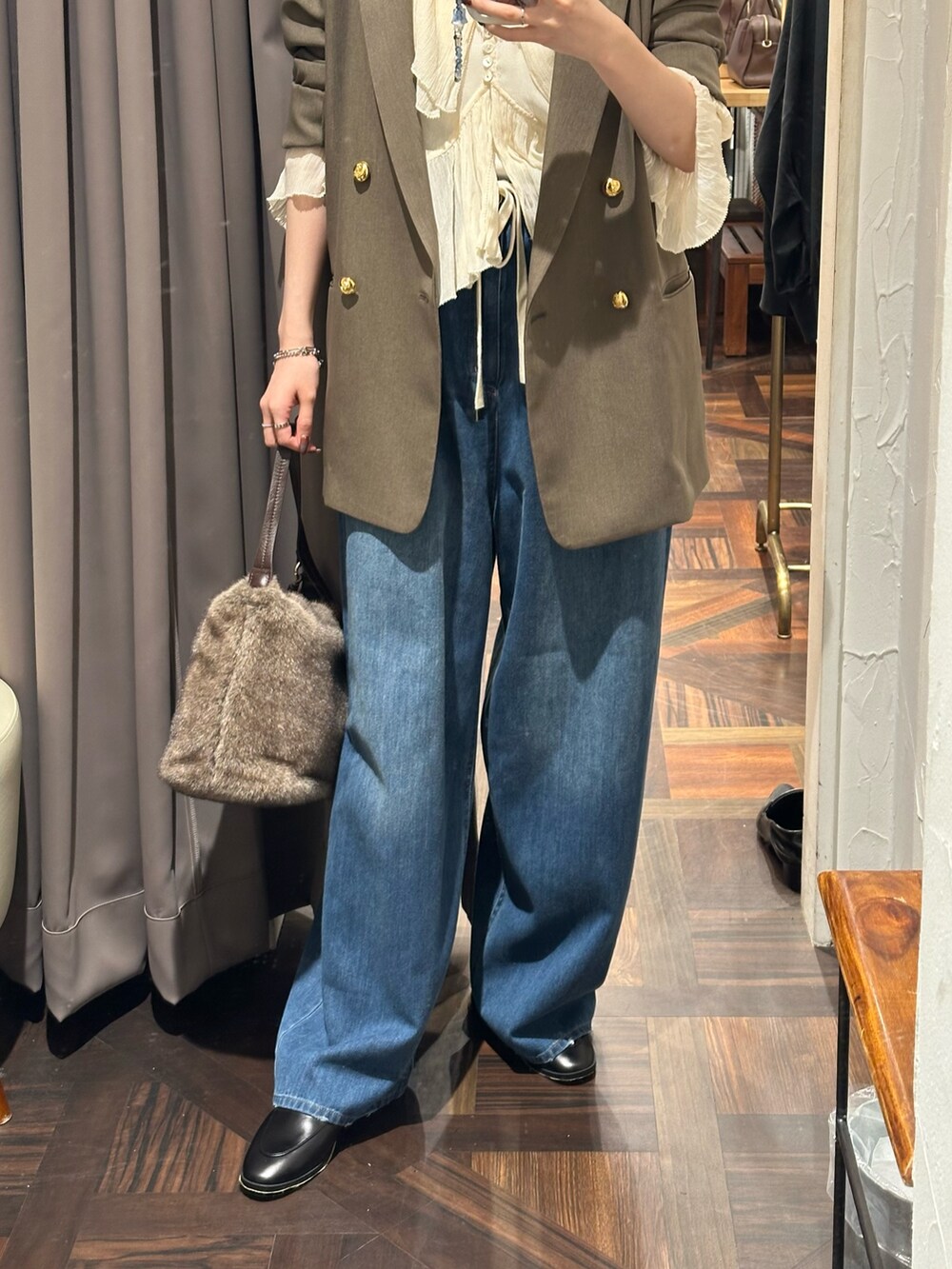 ブラウン系のテーラードジャケット、ホワイト系のシャツ/ブラウス、ブルー系のデニムパンツを着用したレディースの秋コーディネートの3枚目の写真