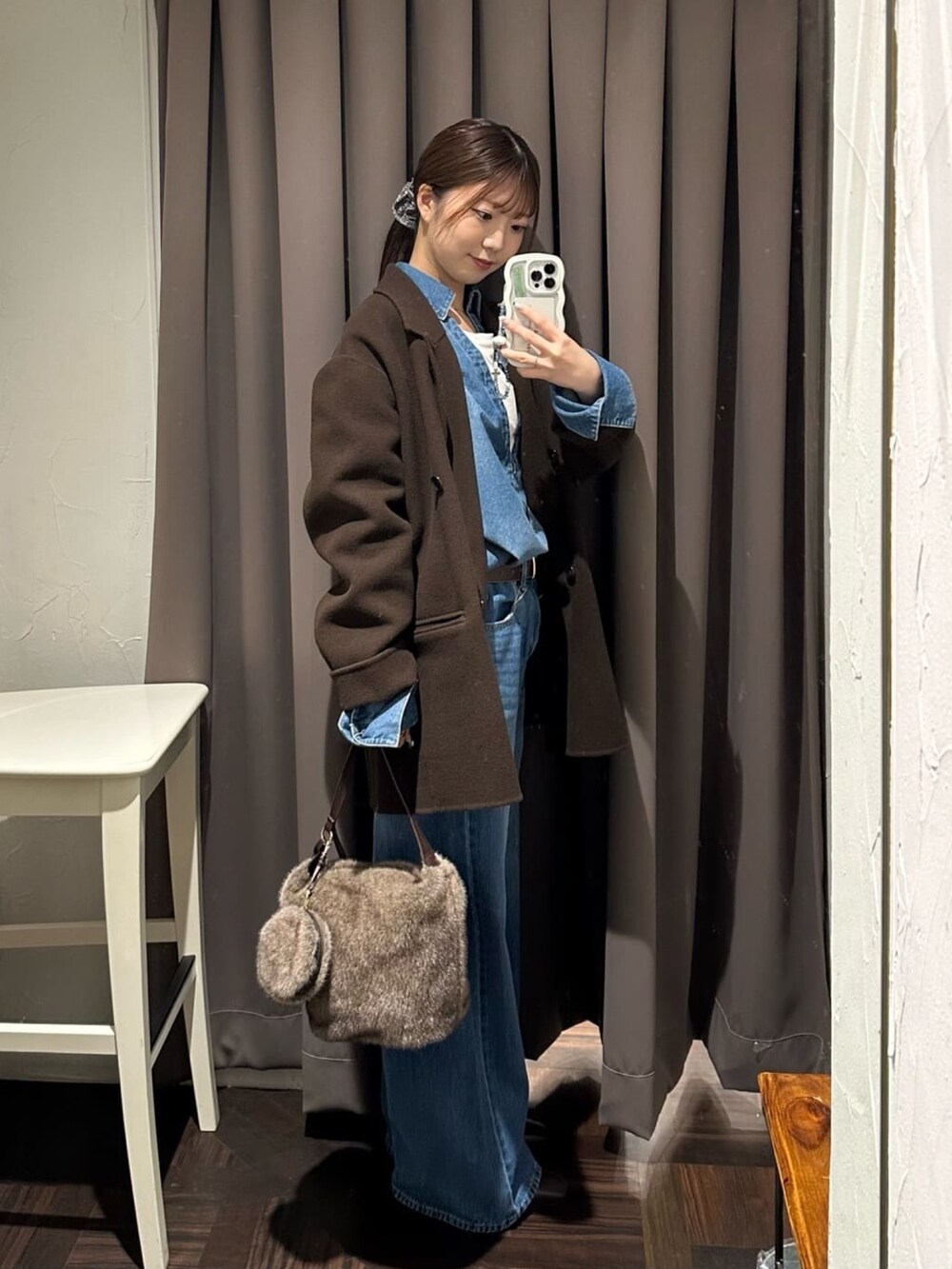 ブルー系のデニムパンツ、ブルー系のシャツ/ブラウス、ブラウン系のハンドバッグを着用したレディースの秋コーディネートの2枚目の写真