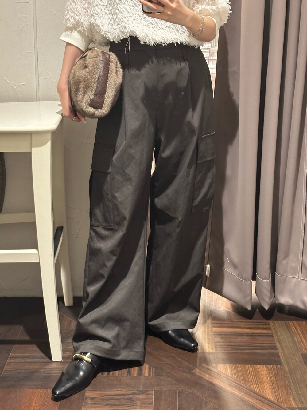 ブラウン系のカーゴパンツ、ホワイト系のシャツ/ブラウス、ブラウン系のハンドバッグを着用したレディースの秋コーディネートの3枚目の写真