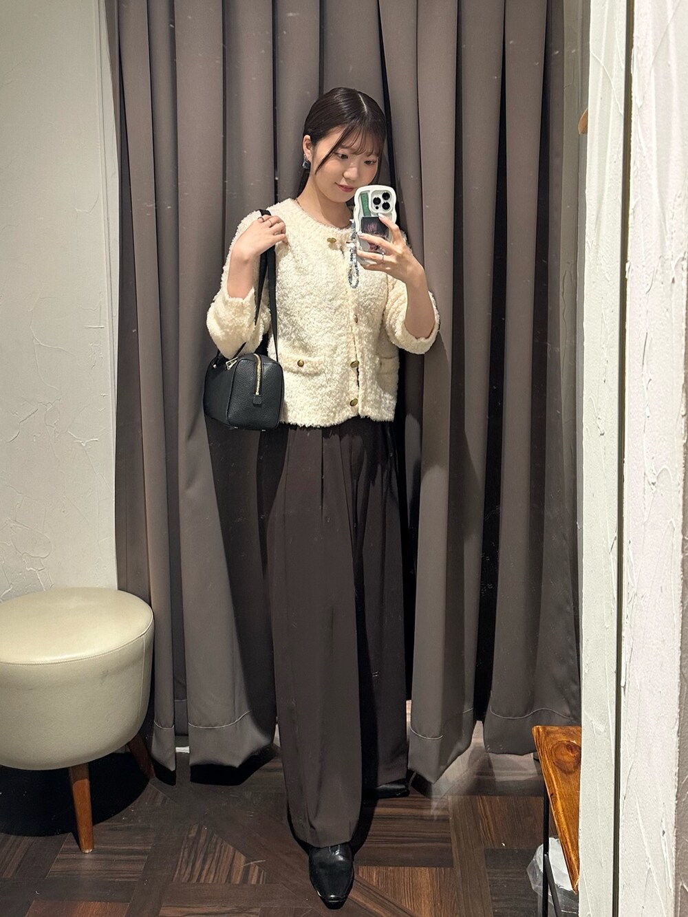 ブラウン系のスラックス、ホワイト系のカーディガン/ボレロ、ブラック系のショルダーバッグを着用したレディースの秋コーディネートの5枚目の写真