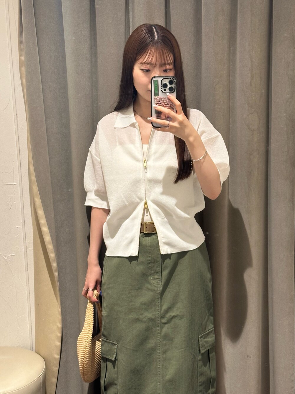 グリーン系のスカート、ホワイト系のパーカーを着用したレディースの夏コーディネートの3枚目の写真